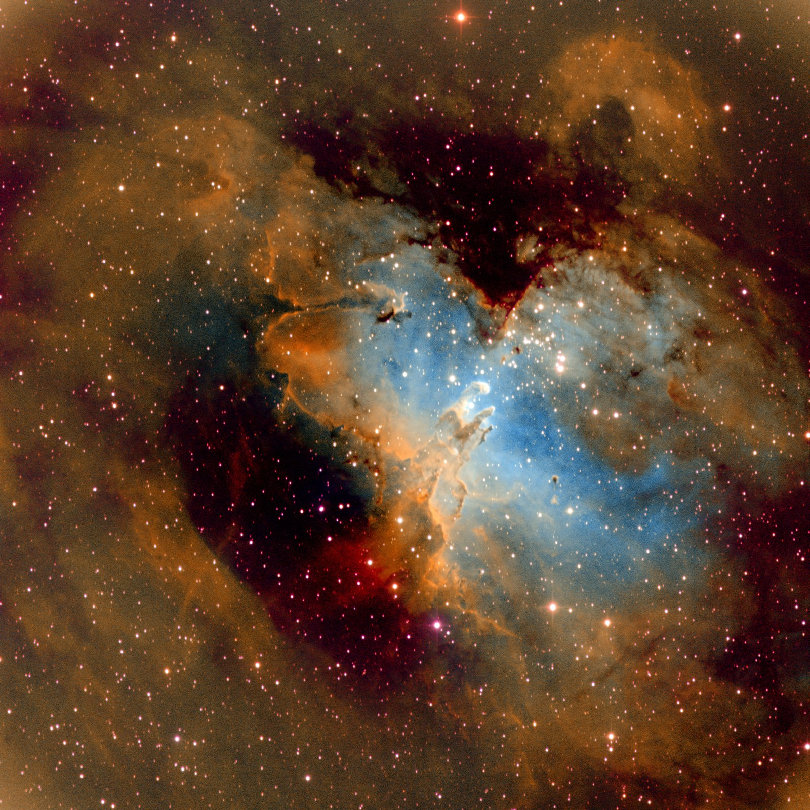 A star field filled with glowing gas in gold and orange, opening in the center into a blue hollow where three small dark columns rise, with darker red dust lanes across the top and lower left.